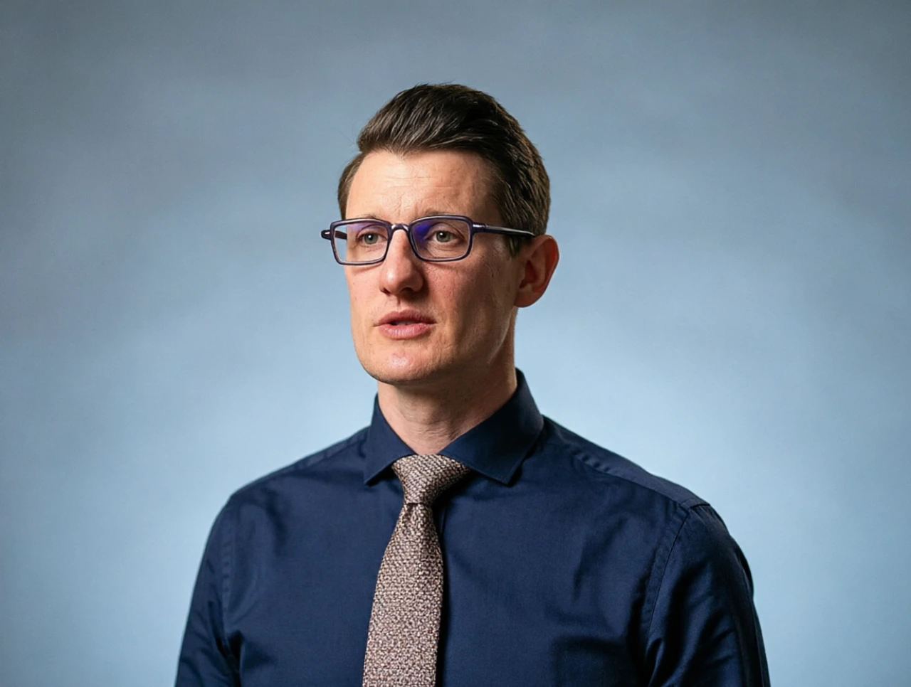 Carl Dvorak professional headshot - former Epic Systems President in navy blue shirt and tie with glasses